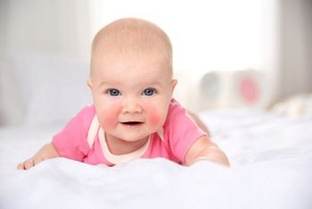 Pretty baby lying on bed at home, closeup