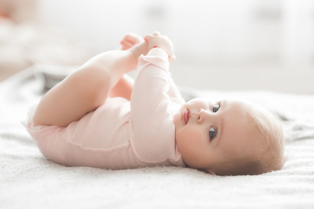 Adorable little baby portrait. Cute baby girl indoor. 6 month child smiling.