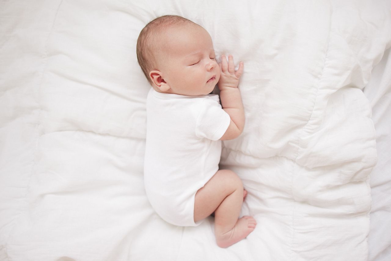 little baby sleeping on a white bed