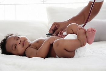 african american baby girl being health checkup with stethoscope