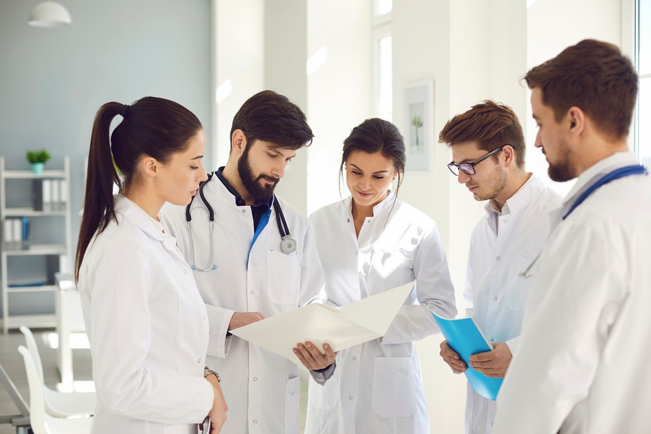 A team of doctors in a meeting discusses the diagnosis of a patient in a clinic office. Teamwork of doctors at the conference of colleagues in the hospital. Profession practicing doctor.