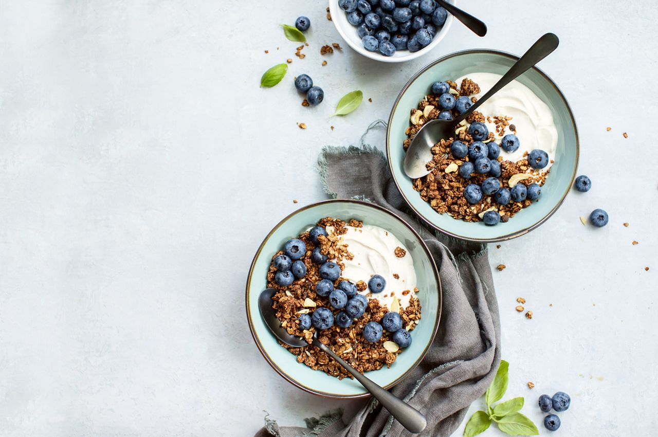 Granola and blueberry breakfast with plain yogurt, top down view, space for a text