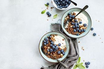 Granola and blueberry breakfast with plain yogurt, top down view, space for a text
