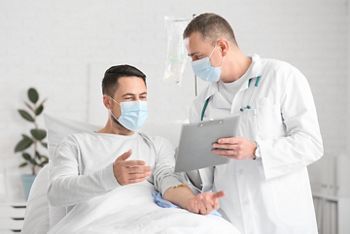 Doctor and man undergoing course of chemotherapy in clinic. Prostate cancer awareness concept