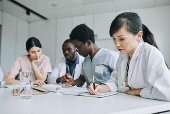 Diverse group of doctors working together at meeting table during medical conference