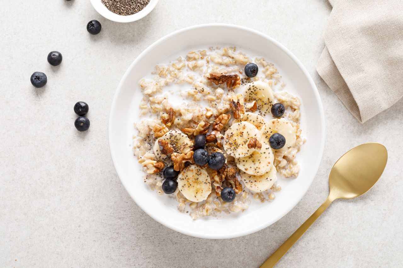 Oatmeal bowl. Oat porridge with banana, blueberry, walnut, chia seeds and almond milk for healthy breakfast or lunch. Healthy food, diet. Top view. 