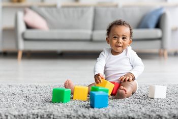 Development Games For Babies. Cute African American Infant Child Playing With Stacking Building Blocks At Home, Adorable Little Baby Sitting On Carpet In Living Room And Looking At Camera, Copy Space