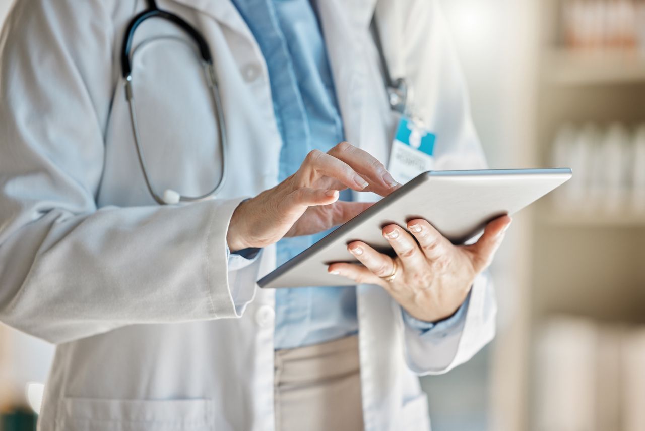 Doctor, office and tablet for research, email or communication. Medic, hospital and reading article, data or health magazine on web, while working with technology in healthcare center or clinic.
