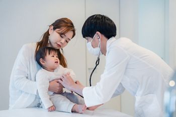 笑顔でドクターの診察を受ける赤ちゃん
