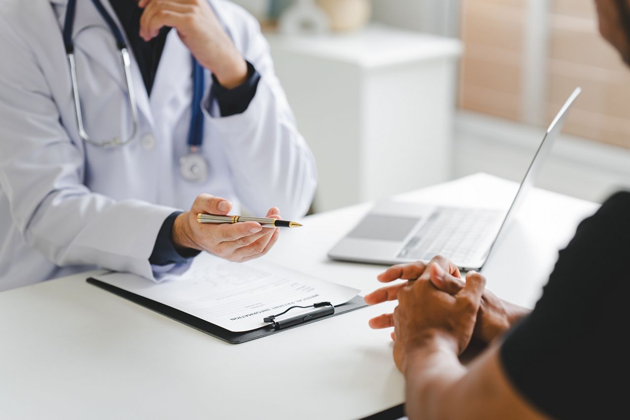 Doctor talking to patient and filling patient history, examination, treatment, medical and health concept.	