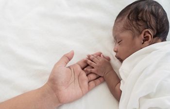 African black parent hands holding newborn baby fingers, Closeup mother’s hand holding their new born baby day. Together love harmony family nursery healthcare and medical father’s day concept banner