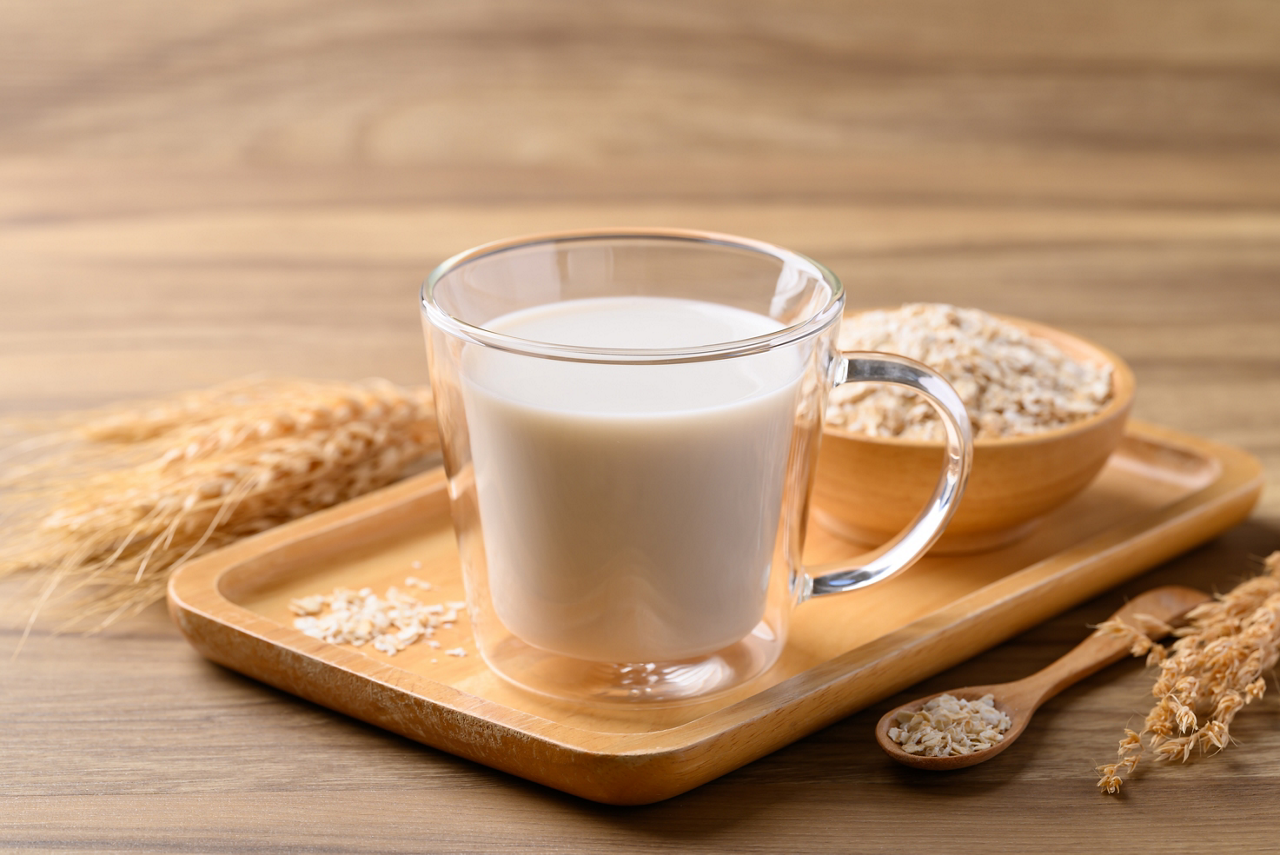 2AE61D7F-AE36-40C7-B6EC9870F62919E7<br>FR - Visuel article Atouts boisson avoine<br>Oat milk in cup glass on wooden background, Alternative milk made from plant, dairy free; Shutterstock ID 2562000537; purchase_order: Articles x2 lait amande et avoine ; job: ; client: ; other: