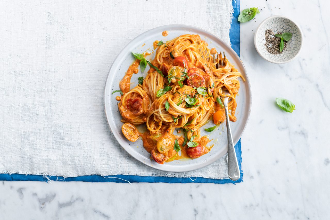 9433EB65-FCE9-4496-BEBE40E3E10EE271<br>A_Cream_NA_Master_Recipe_Image_tomatoredpepperpastacookingsoy___PBAC_NA_Soy_NA_TetraFresh_250ml_HR_horizontal_nopack.tif<br>SPAGHETTI IN A RICH ROASTED TOMATO & PEPPER SAUCE - VIBRANT AND CREAMY WITH A HINT OF SPICE, MADE WITH ALPRO COOKING SOYA OR PBAY PLAIN NO SUGARS

5 large tomatoes
2 cloves garlic
2 onions
250g mixed cherry tomatoes 
1 tsp chili powder
2 tsp curry powder
20 g fresh basil
250g grilled peppers (from a jar)
400g vegan & gluten-free spaghetti 
250ml Alpro Cooking Soya OR 250g Alpro plant based alternative to yoghurt plain No Sugars 

1. Start by preheating your oven to 160°C, line a baking tray with parchment paper and bring a large pot of salted water to the boil. 
2. Cut the large tomatoes and one of the cloves of garlic in two, and coarsely chop one of the onions. Pile them into your lined tray, drizzle with olive oil and season with salt and pepper. Roast in the oven for 40 minutes. 
3. Finely dice the rest of the onion and garlic, warm olive oil in a large skillet and sauté them over a medium heat until soft. Halve the cherry tomatoes. Season the onions and garlic with salt, pepper, chili powder and curry powder, then toss in the cherry tomatoes, turn down the heat and sauté for 5 more minutes. 
4. Meanwhile, put the roasted tomatoes, half  the fresh basil and the grilled peppers in a blender and whizz until you have a smooth sauce. Season to taste with salt and pepper. 
5. Cook the pasta according to the instructions on the pack. 
6. Grab your skillet of  veggies, and stir in the pepper sauce and the Alpro Cooking Soy OR Alpro plant based alternative for yoghurt plain No Sugars. Let it all simmer for six more minutes. 
7. Finally, drain the cooked pasta, tumble into the skillet and stir to coat every strand with the sauce. Scatter with the rest of the chopped basil and serve straightaway. 

(Recipe type: DINNER (Prep time: 15 min) (Cooking time: 35) (servings: +/- 4-5 persons) (season: all seasons)