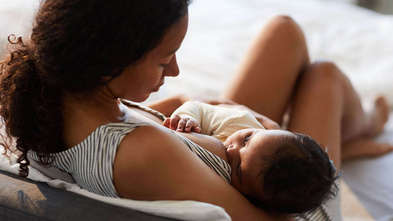 Madre amamantando a su bebé en un momento de conexión y nutrición, destacando los beneficios de la lactancia materna para la salud y el desarrollo del bebé