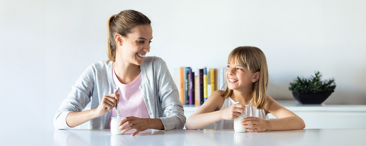 Mamma e figlia mangiano insieme uno yogurt