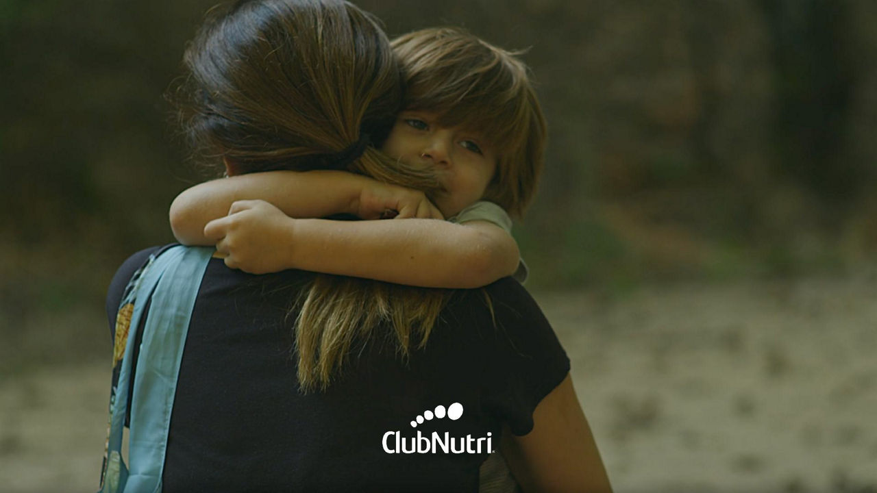 madre abrazando a hijo en un bosque 