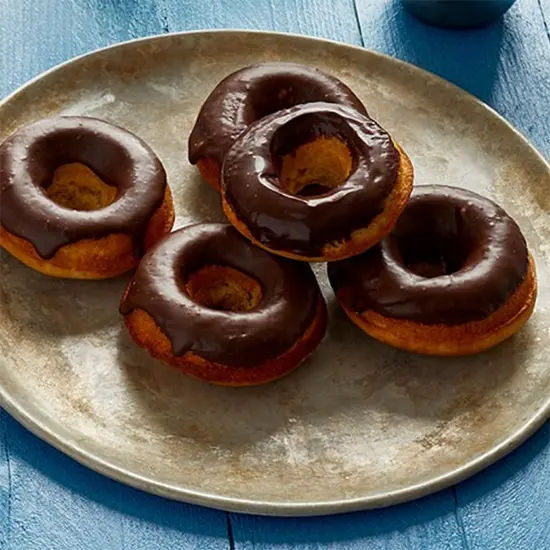 Chocolate-glazed donuts on rustic plate