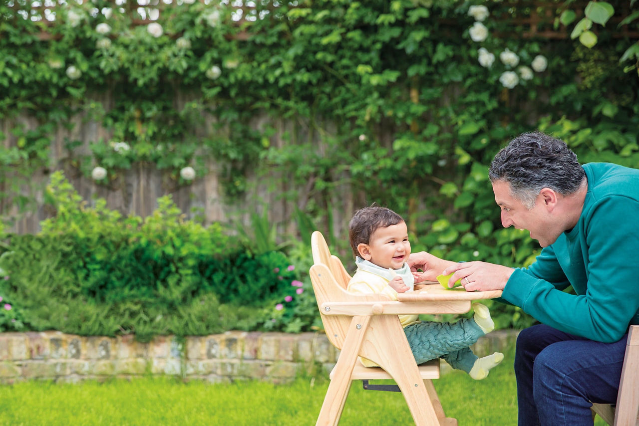 dad feeding baby outside