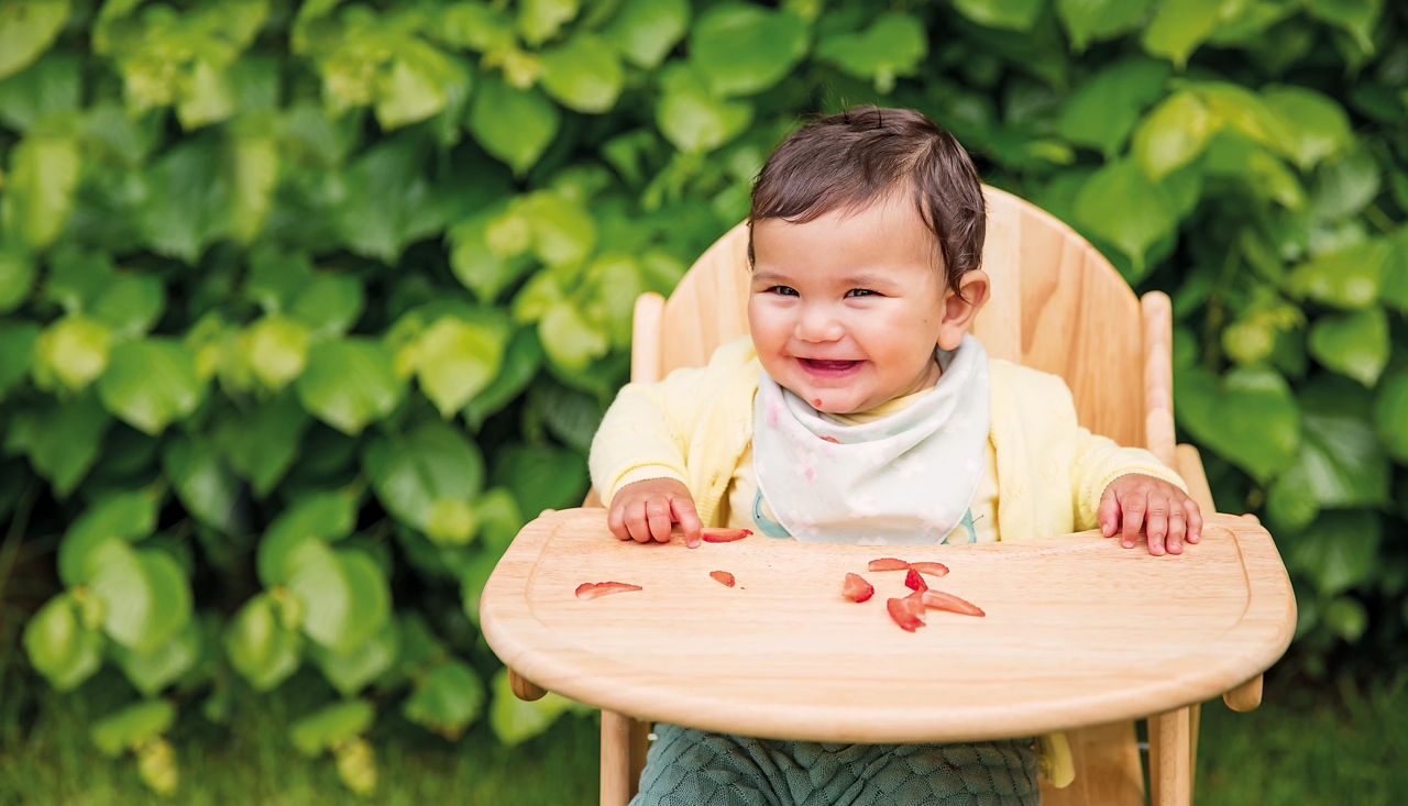 Toddler eating strawberries outside