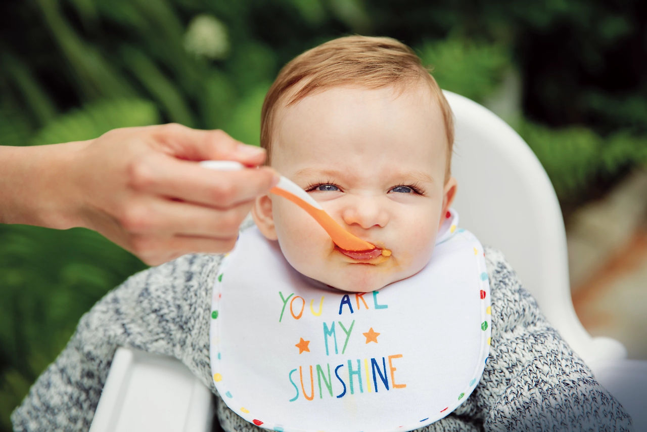 Mum spoon feeding baby