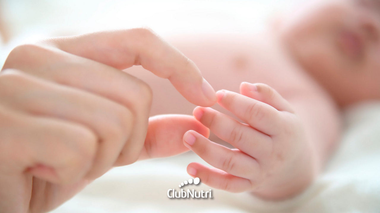Mano de la madre con la mano de un bebé