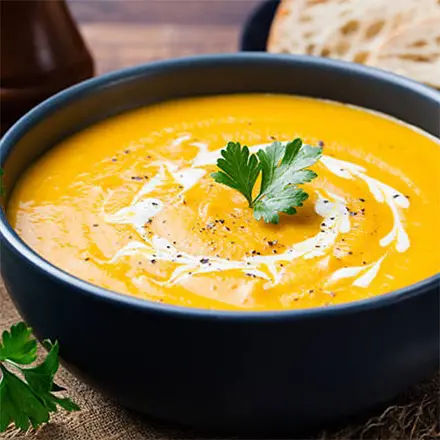 Creamy pumpkin soup in black bowl