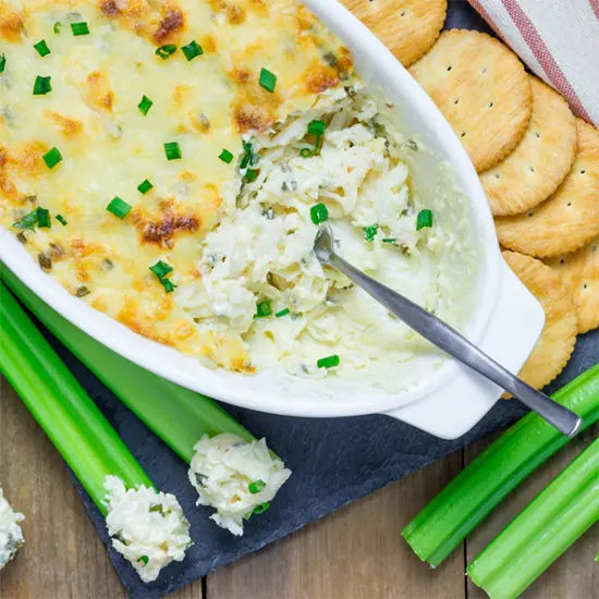 Cheesy baked dip with crackers and celery