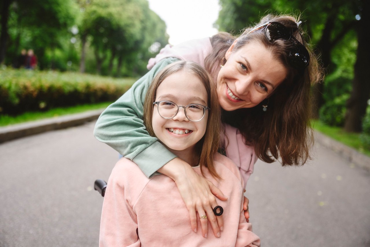 Happy mother hugging her daughter in park