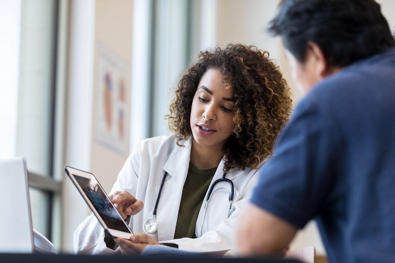 Ärztin mit Patient am Tablet