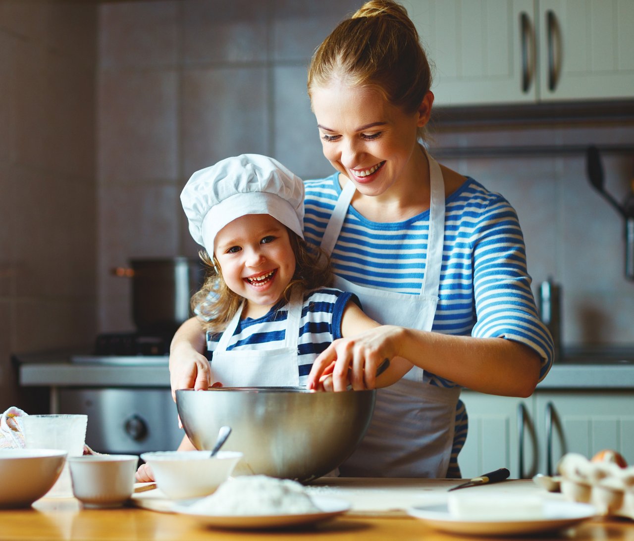 happy family in the kitchen. mother and  child daughter preparing the dough, bake cookies