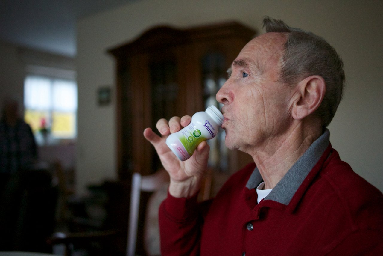 Mann mit Alzheimer-Krankheit trinkt ein Fläschchen Souvenaid