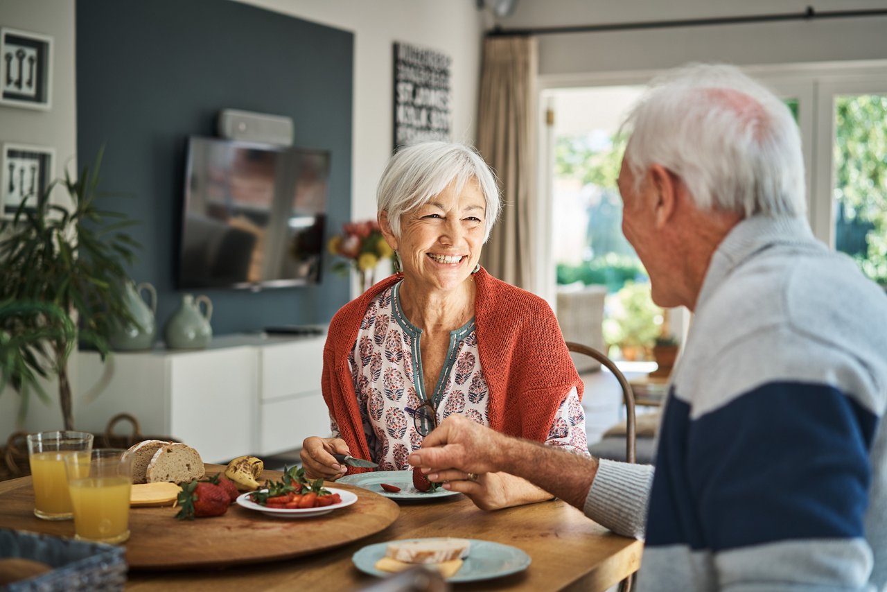 Glückliches Ehepaar hält sich beim Essen an den Händen