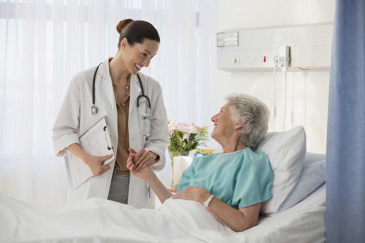 aerztin_patientin_seniorin_sprechen_krankenhausbett_GettyImages-184312691