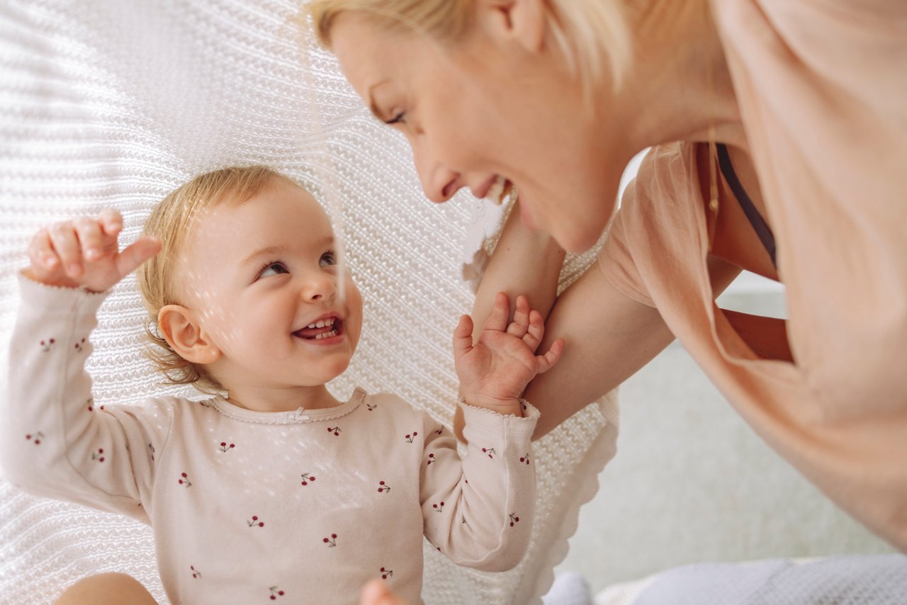 Kleinkind mit Kuhmilcheiweißallergie lächelt Mutter an