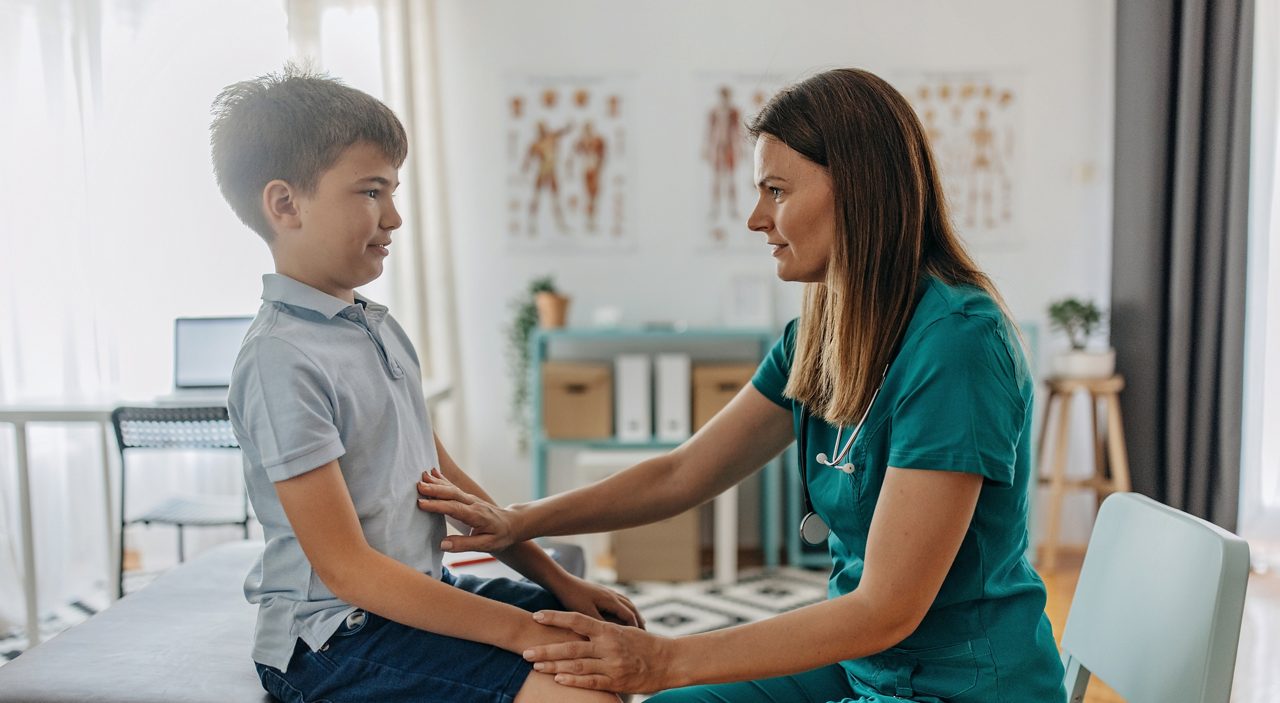 Female paediatrician is examining elementary age boy