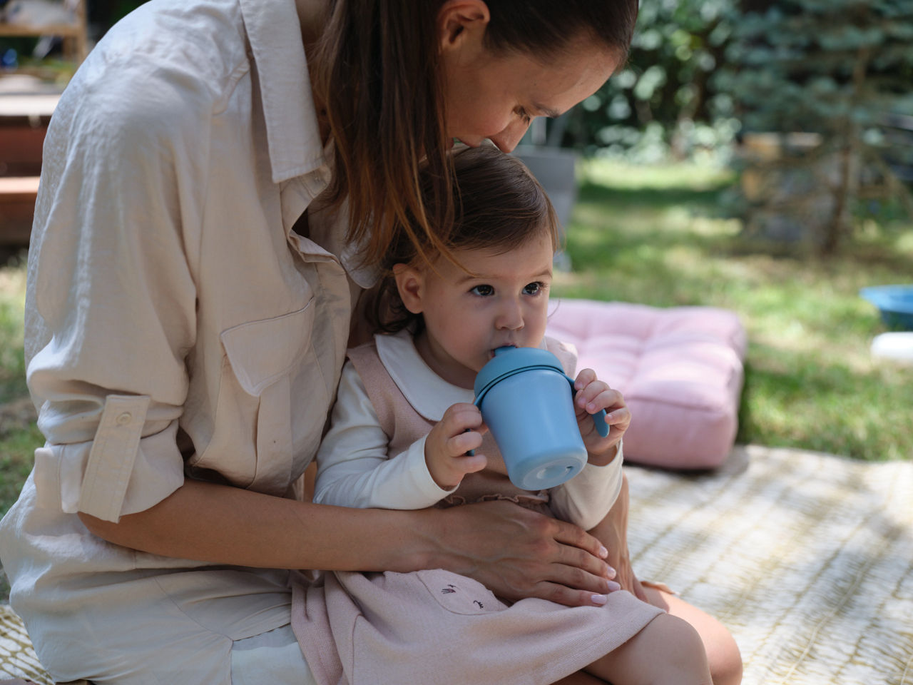Girl drinking from feeding baker