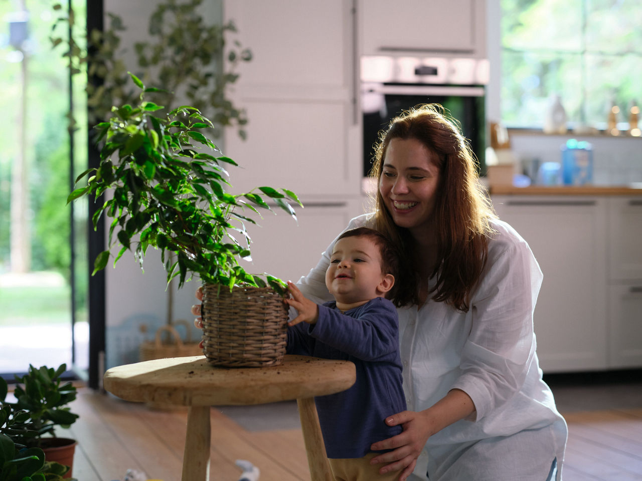 mom and child reaching for plant