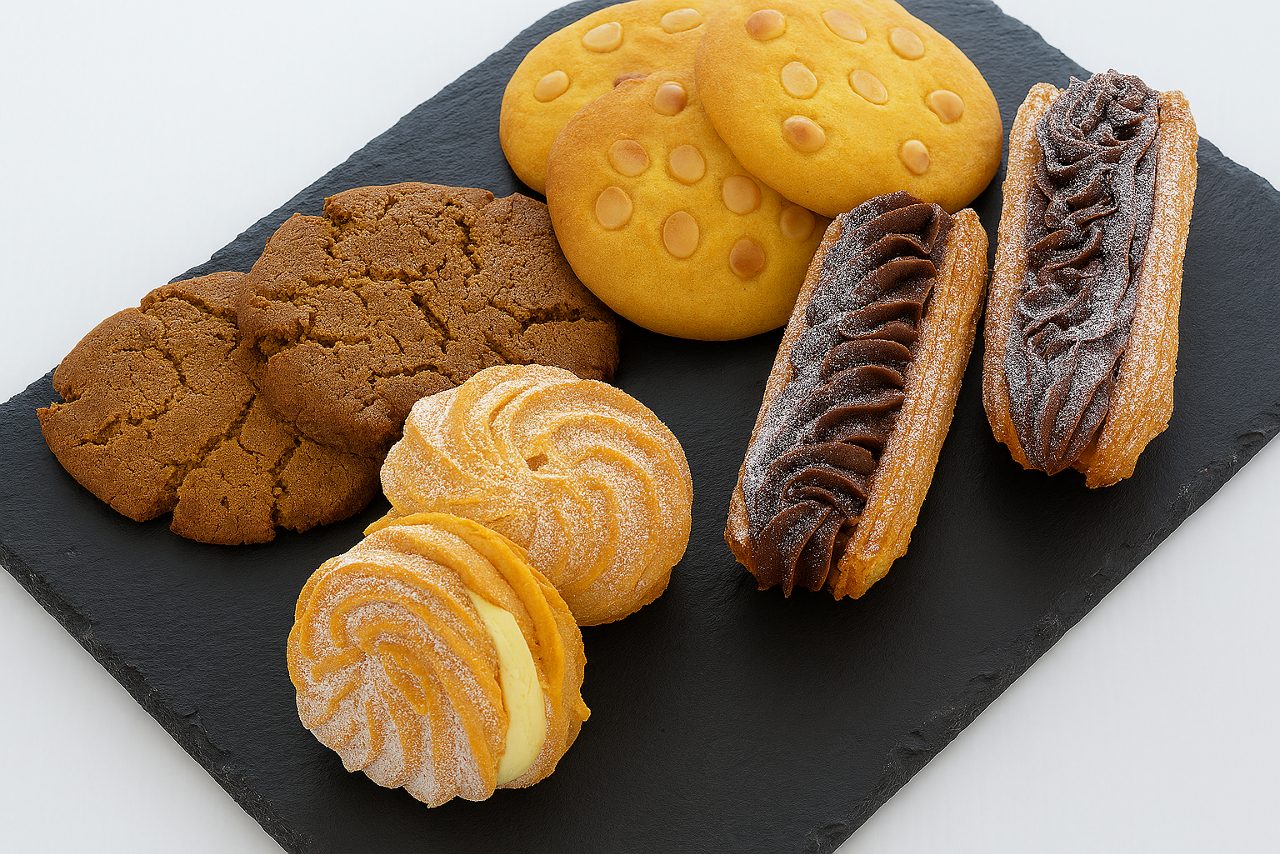 Bundt cake topped with fresh orange slices, surrounded by orange segments on a wooden table.