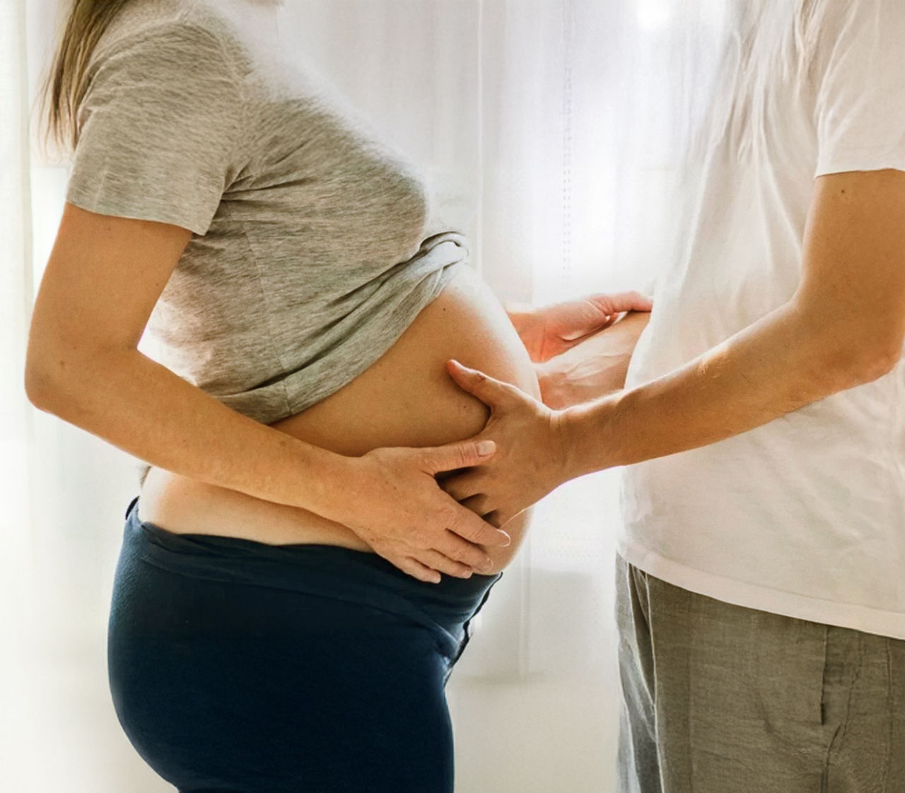padre con manos en la panza de la madre
