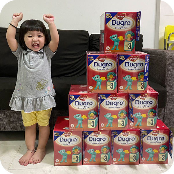 Little girl and boxes pyramid with Dugro Milk stage 3 products