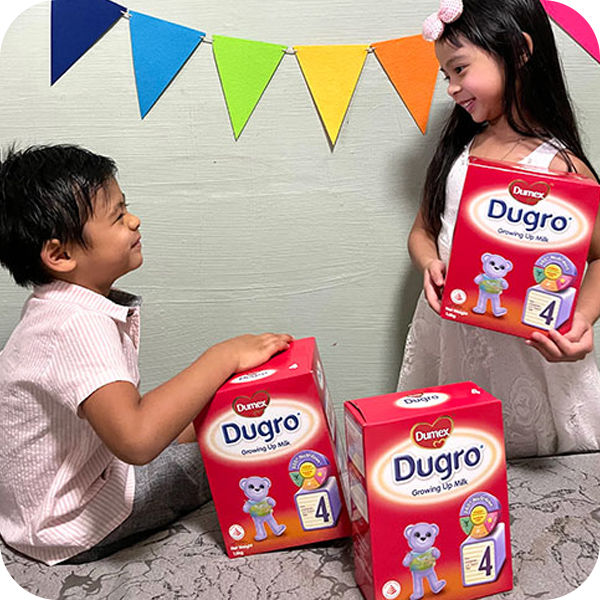 Children talking and holding Dumex Dugro Stage 4 milk powder