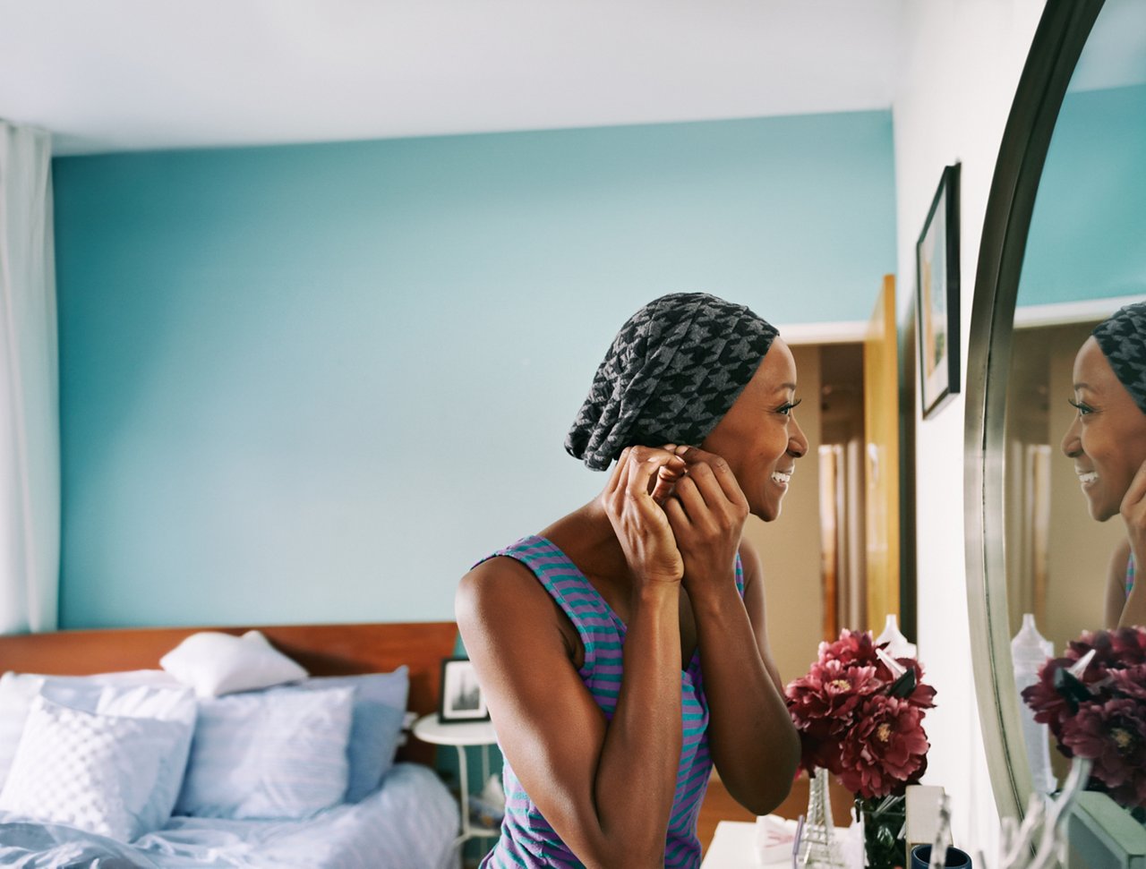 Personne se regardant dans un miroir dans une chambre, impact de la dénutrition pendant et après un traitement contre le cancer