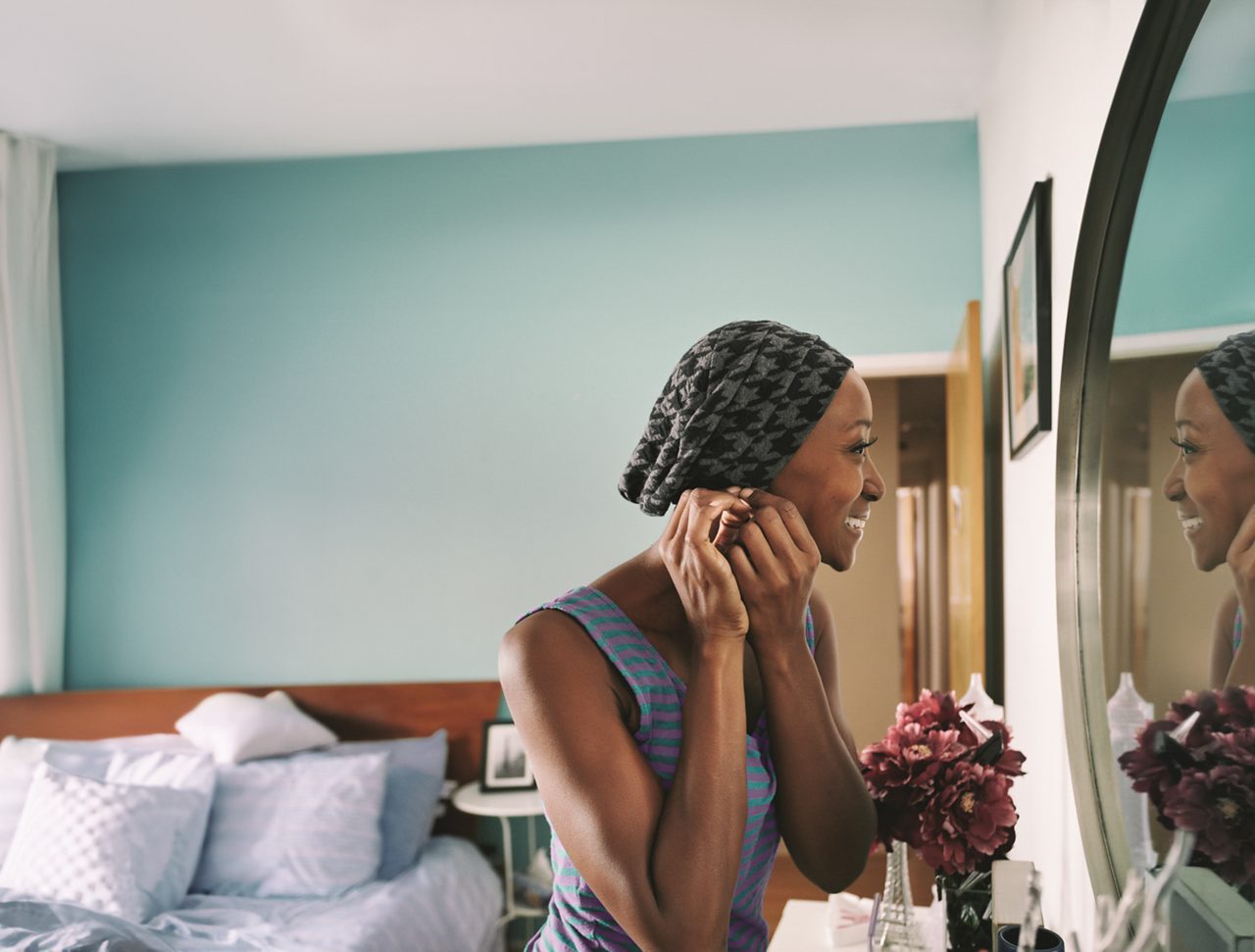 Female cancer patient fixing ear-ring