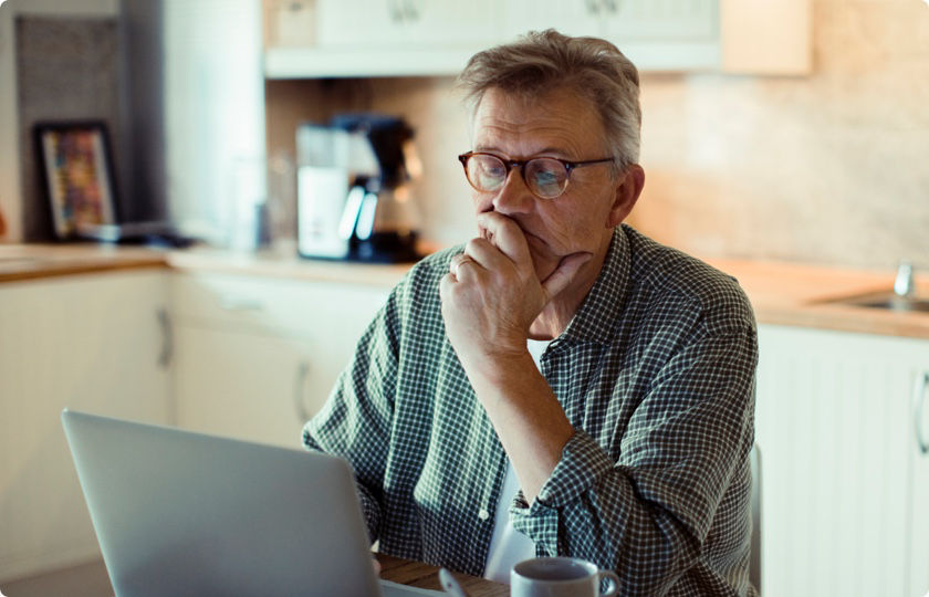 Older man sitting and working on his laptop