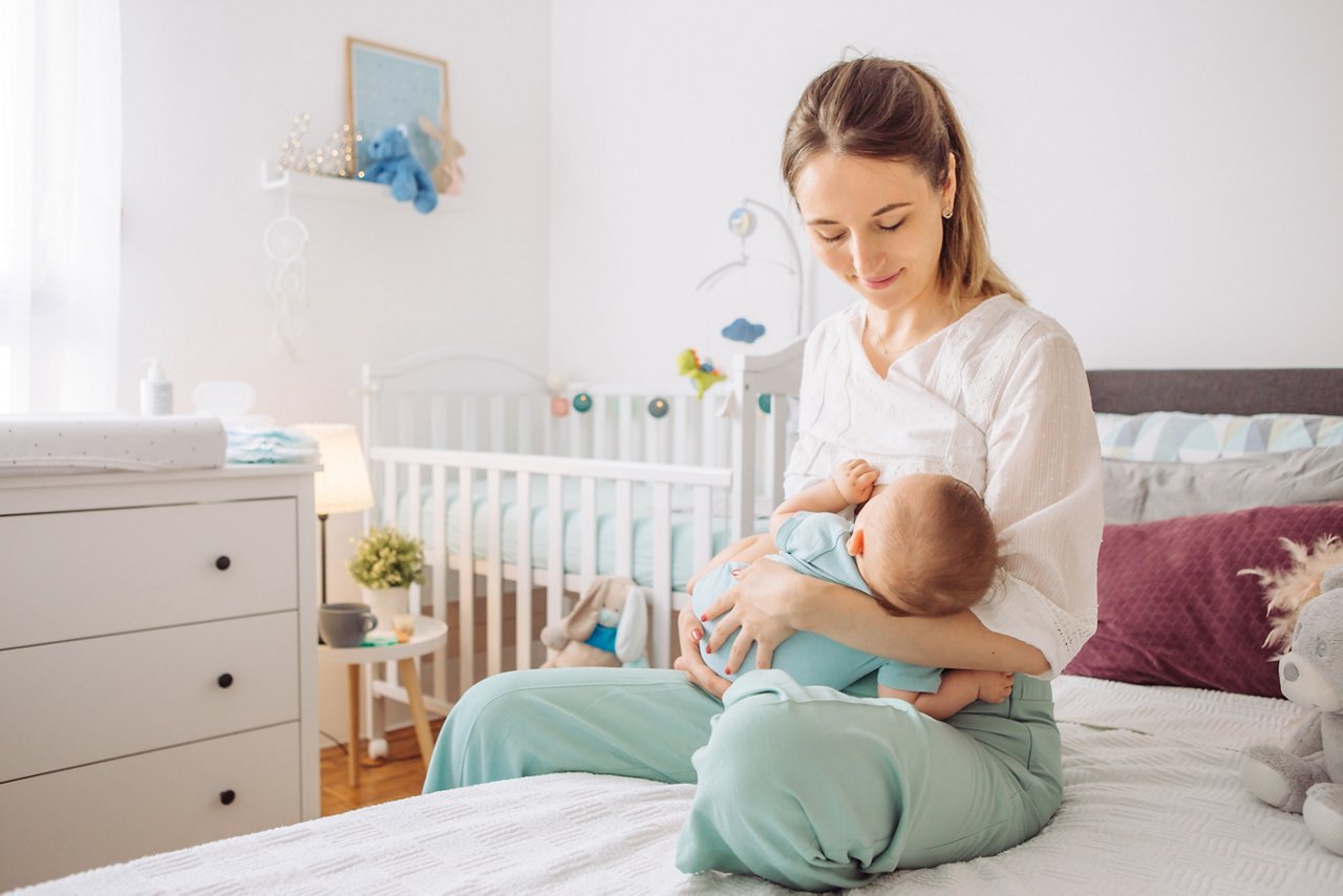 Mother breastfeeding baby son in bedroom, they enjoy in this moment together getty images 1156476558