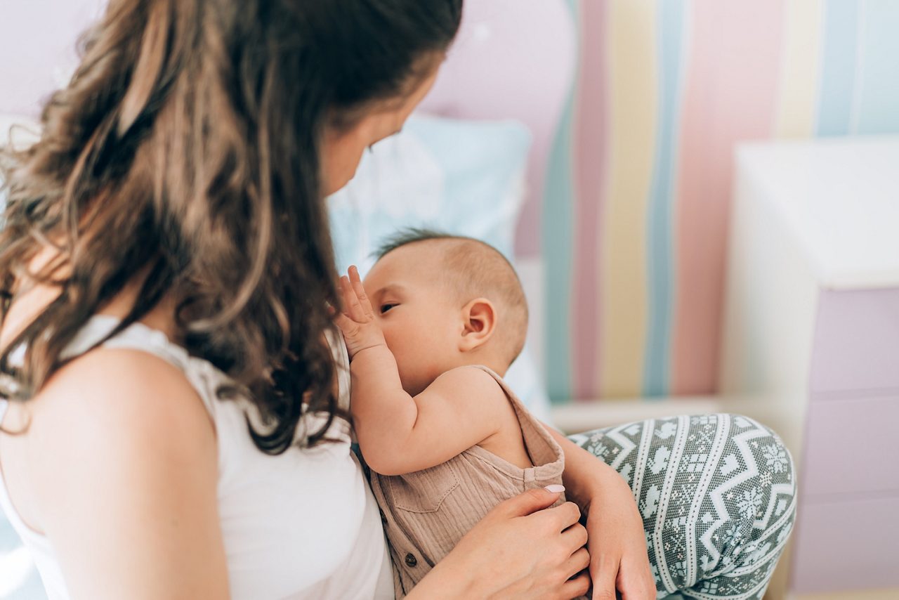 Young mother is breastfeeding her baby. In Vitro Fertilization (IVF). Family of asians. getty images 1314661509