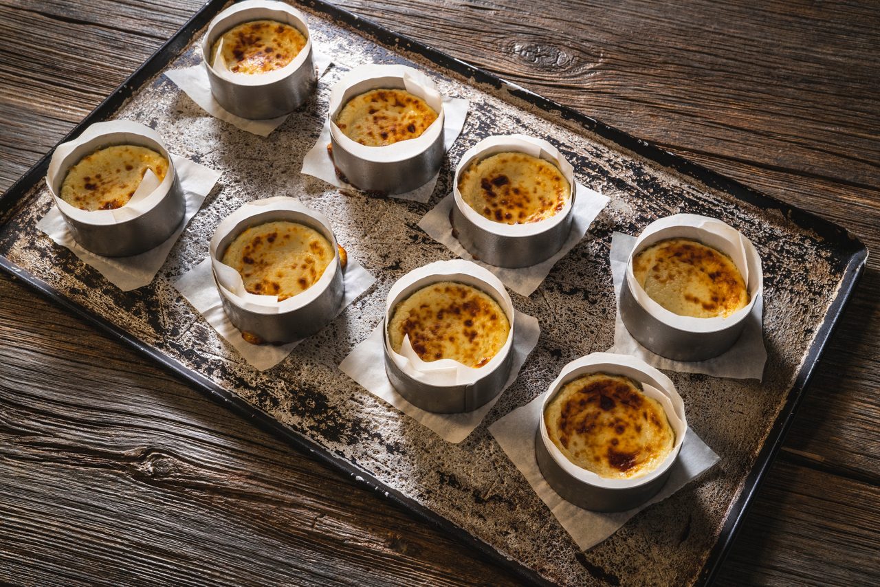 Cheesecakes small individual serving size in a row on the oven tray full frame