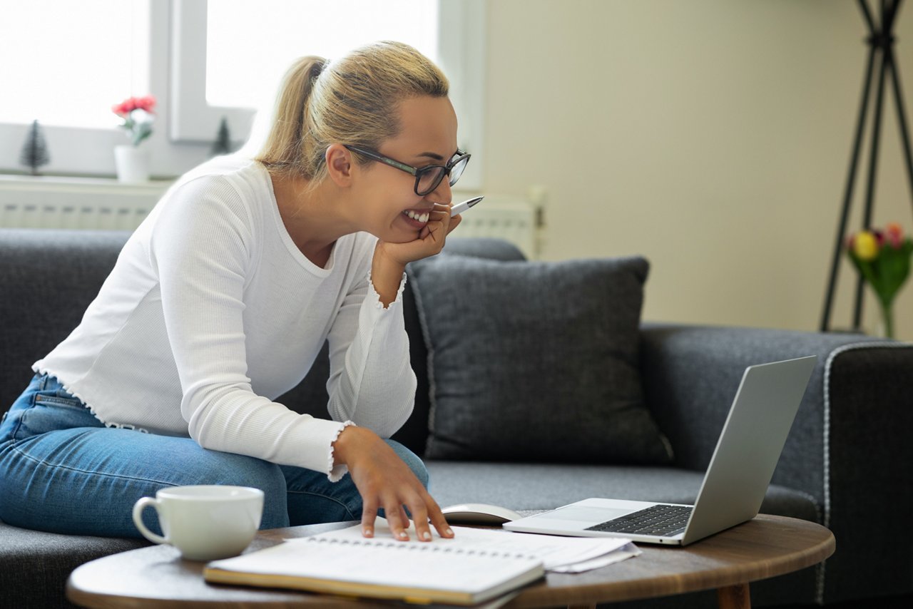 Frau lächelt vor dem Laptop 