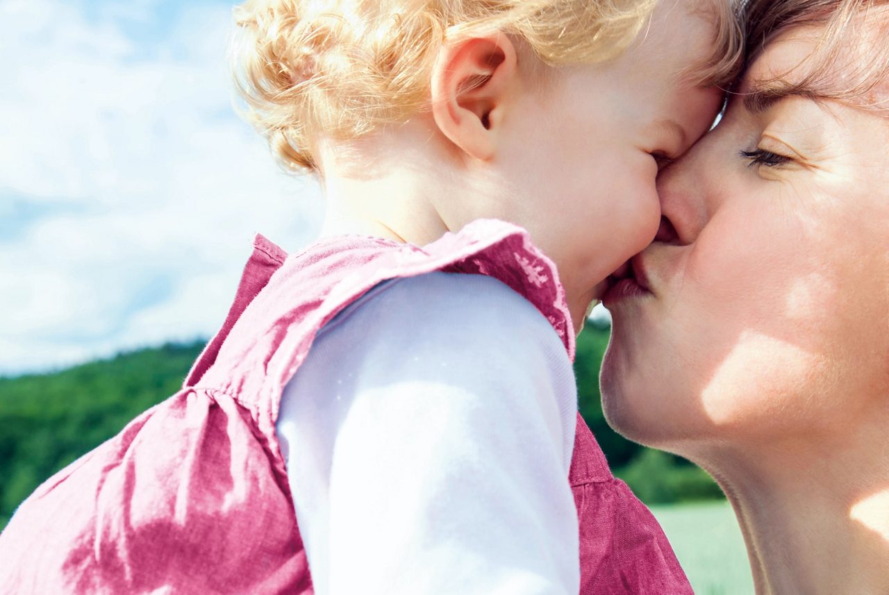 mum kissing baby girl