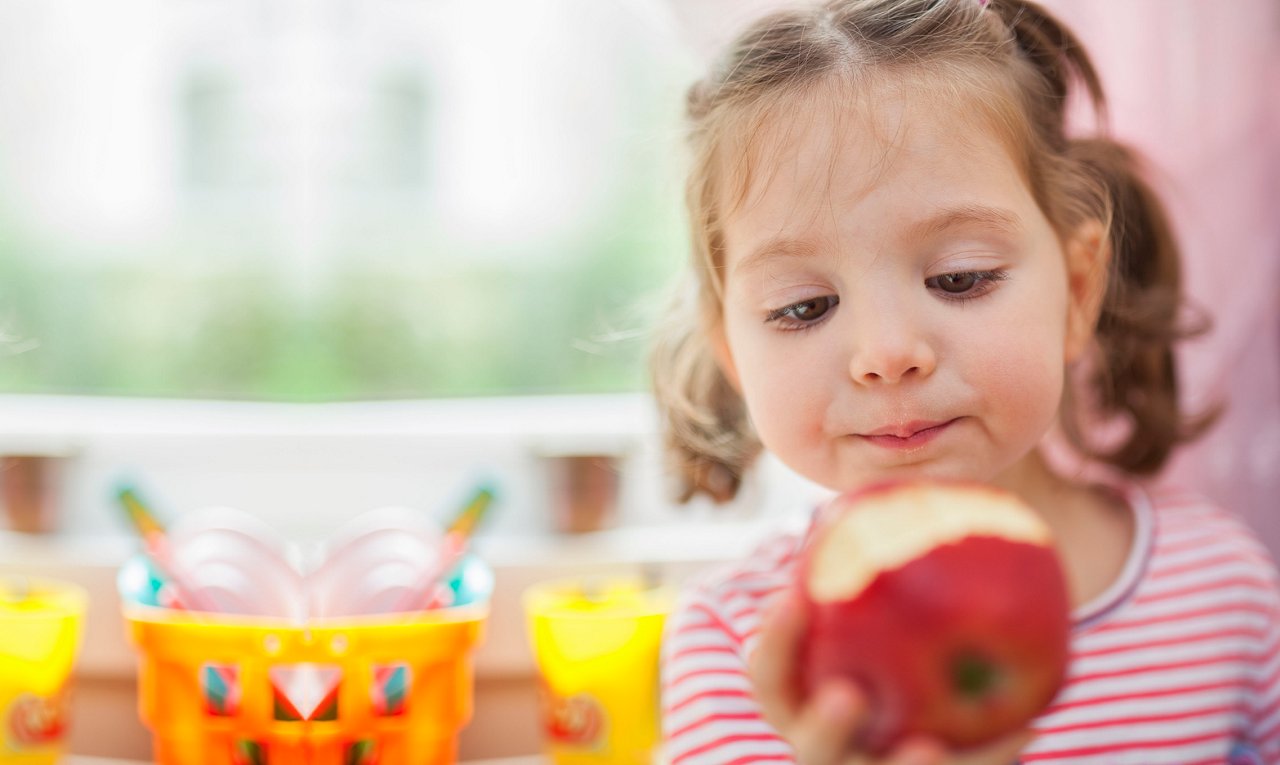 Closeup photograph of  little cute girl eating apple getty images 523734631